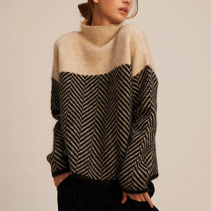 Frau trägt warmen Strickpullover mit Zickzackmuster in Beige und Schwarz, modisch und gemütlich, ideal für Herbstmode und Winterkleidung.