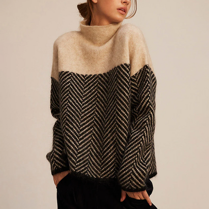 Frau trägt warmen Strickpullover mit Zickzackmuster in Beige und Schwarz, modisch und gemütlich, ideal für Herbstmode und Winterkleidung.