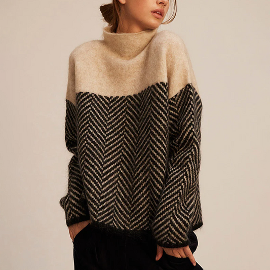 Frau trägt warmen Strickpullover mit Zickzackmuster in Beige und Schwarz, modisch und gemütlich, ideal für Herbstmode und Winterkleidung.