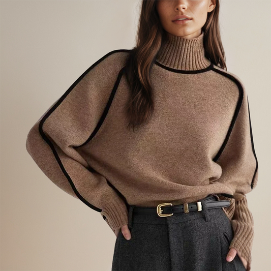 Frau in braunem Rollkragenpullover mit schwarzen Akzenten, kombiniert mit grauer Hose und Gürtel. Modetrend, Herbstmode, eleganter Look.