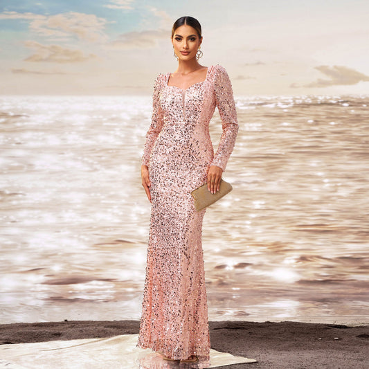 Elegante Frau in glitzerndem, rosa Abendkleid am Strand, hält goldene Clutch. Sonnenuntergang am Meer im Hintergrund. Glamouröse Modefotografie.