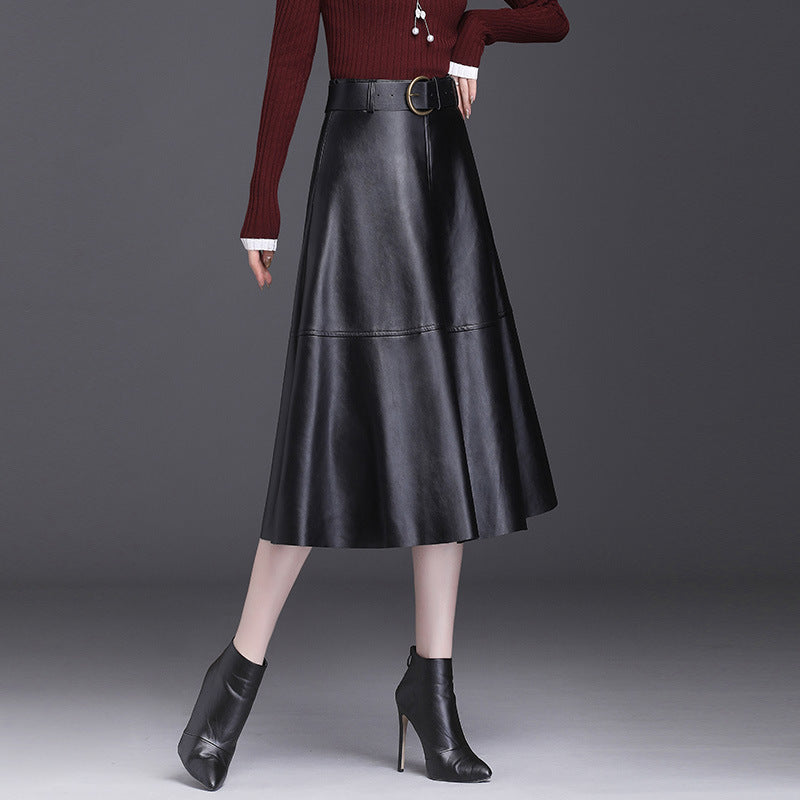 Damenmode: Eleganter schwarzer Lederrock in A-Linie, kombiniert mit rotem Pullover und schwarzen Stiefeletten. Trendige Herbst-Winter-Kleidung.