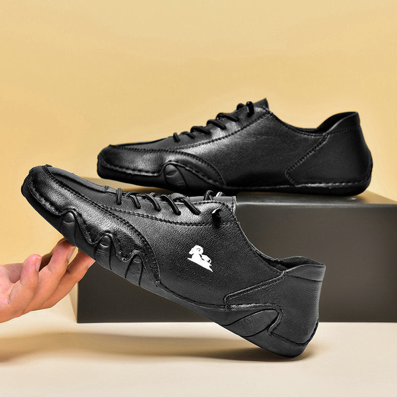 Schwarze Herren-Ledersneaker mit Schnürung, rutschfester Sohle und modernem Design auf beigem Hintergrund. Bequeme Freizeitschuhe für Männer.