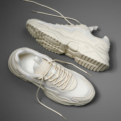 Beige Sneaker auf grauem Hintergrund, moderne Sportschuhe mit dicker Sohle, modisches Design, Herren- und Damenmode, bequeme Freizeitschuhe.