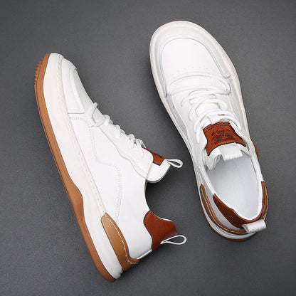 Weiße Sneaker mit braunen Akzenten und Gummisohle auf grauem Hintergrund. Modische Herrenschuhe, ideal für Freizeit und Sport.