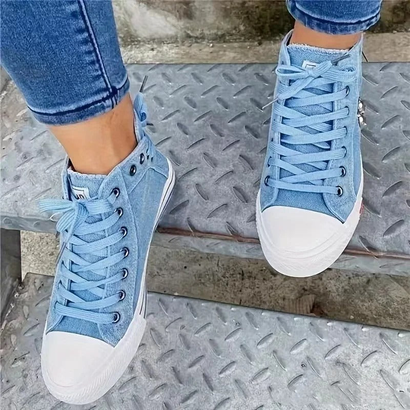 Blaue High-Top-Sneaker aus Denim auf Metalltreppe, modische Freizeitschuhe, Damenjeans, urbaner Stil, bequeme Fußbekleidung.