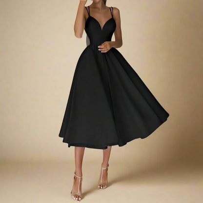 Elegantes schwarzes Abendkleid mit Spaghettiträgern, schwingendem Rock und V-Ausschnitt, getragen von einer Frau, ideal für formelle Anlässe.