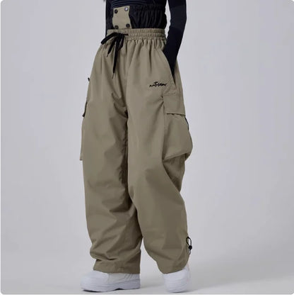 Beige Baggy-Hose mit elastischem Bund und Kordelzug, großen Seitentaschen, getragen von Person. Modetrend, lässiger Streetwear-Stil.