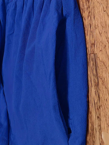 Blaues Hemd aus Baumwolle, hängend an Holzwand. Knitterfreies Design, modisch und elegant. Perfekt für Business- und Freizeitkleidung.