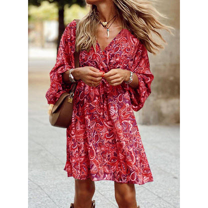 Frau in rotem, geblümtem Kleid mit V-Ausschnitt und langen Ärmeln, trägt braune Tasche und Schmuck, modisch, sommerlich, urbaner Hintergrund.