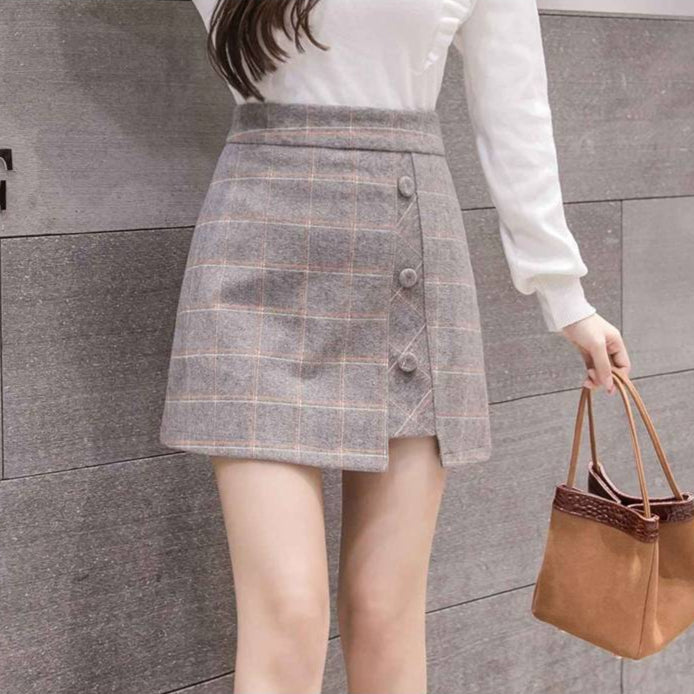 Frau in kariertem Minirock und weißem Pullover, hält braune Handtasche. Modetrend, Damenmode, eleganter Look, Herbstoutfit.