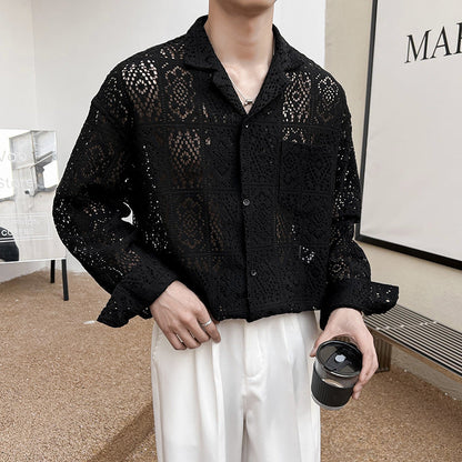 Mann trägt schwarze, durchsichtige Häkelbluse und weiße Hose, hält schwarzen Kaffeebecher. Modetrend, stilvolle Herrenbekleidung, urbaner Look.