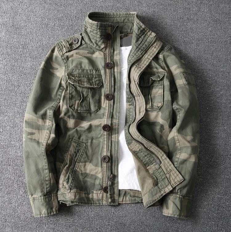 Camouflage-Jacke für Herren auf grauem Hintergrund, mit Knopfleiste und Brusttaschen. Perfekt für Outdoor-Aktivitäten und modische Freizeitkleidung.