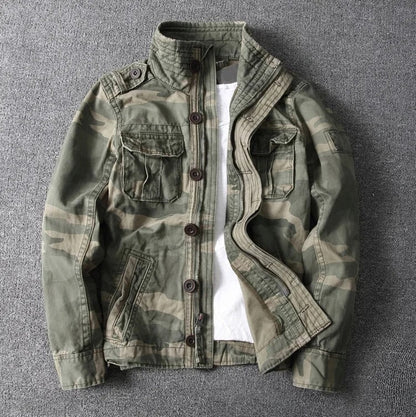 Camouflage-Jacke für Herren auf grauem Hintergrund, mit Knopfleiste und Brusttaschen. Perfekt für Outdoor-Aktivitäten und modische Freizeitkleidung.