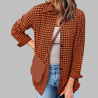 Frau in orange-schwarz kariertem Hemd, hellbraunem Top und blauer Jeans vor grauem Hintergrund. Modetrend, lässiger Stil, Herbstmode.