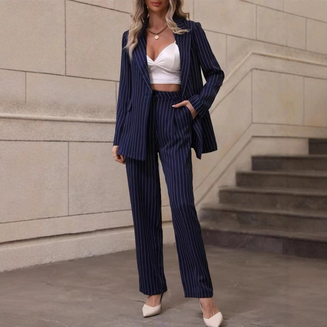 Frau in blauem Nadelstreifenanzug und weißem Crop-Top, steht vor einer Treppe. Elegante Businessmode, moderne Damenbekleidung, stilvoller Look.