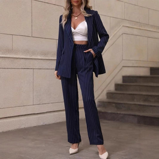 Frau in blauem Nadelstreifenanzug und weißem Crop-Top, steht auf Treppe. Elegante Businessmode, moderne Damenbekleidung, stilvoller Look.