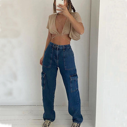 Frau in modischer Kleidung: Beige Crop-Top, blaue Cargo-Jeans, Leoparden-Sneaker. Trendige Streetwear, lässiger Stil, moderne Mode.