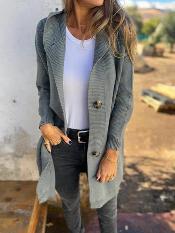 Frau in grauem Strickmantel und weißem T-Shirt, lässiger Herbstlook, modische Damenbekleidung, Outdoor-Hintergrund, stilvolle Freizeitmode.