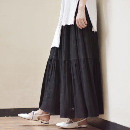 Schwarzer Maxirock und weiße Bluse, kombiniert mit eleganten weißen Schnürschuhen. Modetrend, Damenmode, stilvoller Look.