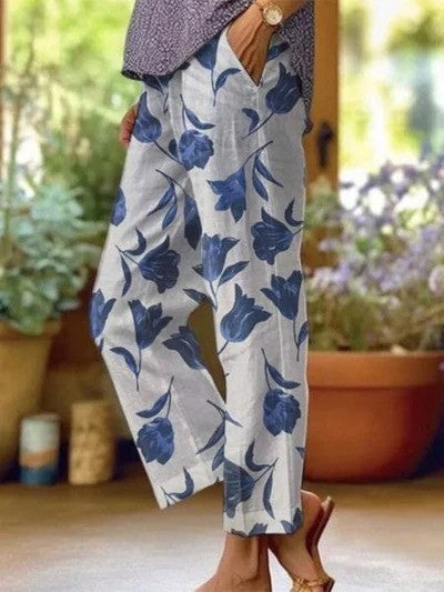 Damenhose mit blauem Blumenmuster, lässig geschnitten, aus leichter Baumwolle. Perfekt für den Sommer. Elegante Freizeitmode für Frauen.