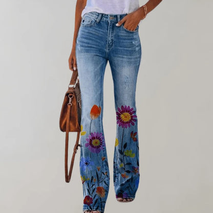 Frau in blauer Jeans mit buntem Blumenmuster, weißem T-Shirt und brauner Handtasche. Modetrend, Damenjeans, florales Design.