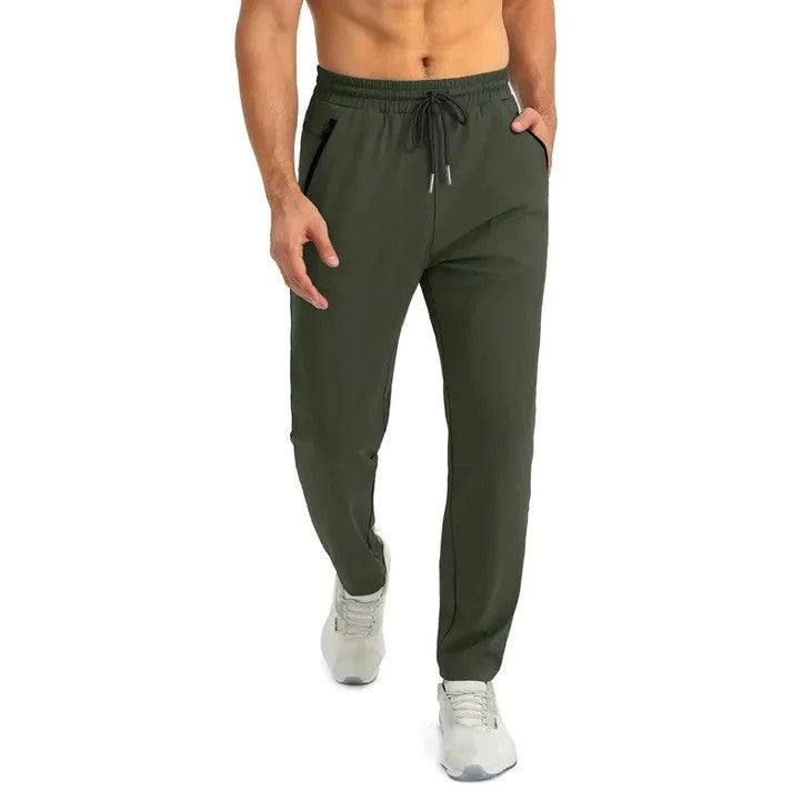Mann in olivgrüner Jogginghose, sportlich, mit Kordelzug und Taschen, trägt weiße Turnschuhe. Ideal für Fitness und Freizeit.
