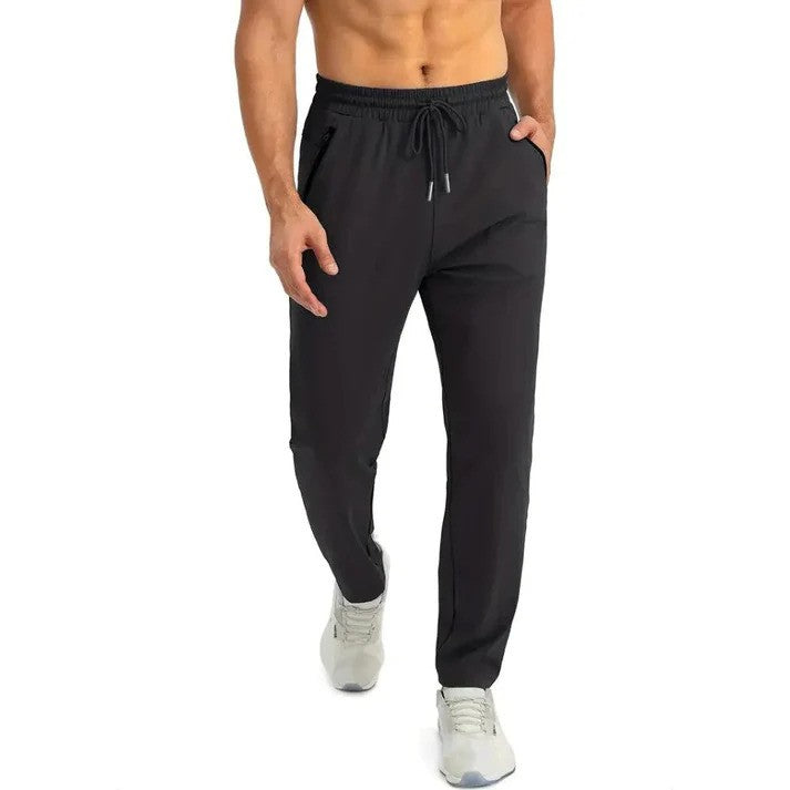 Mann in schwarzen Jogginghosen und grauen Sneakers, sportlich, lässig, Fitnessmode, bequeme Sportbekleidung, ideal für Training und Freizeit.