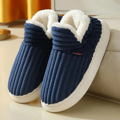 Blaue Hausschuhe mit weißem Fleecefutter, rutschfeste Sohle, gemütlich und warm, ideal für den Winter, auf hellem Hintergrund.