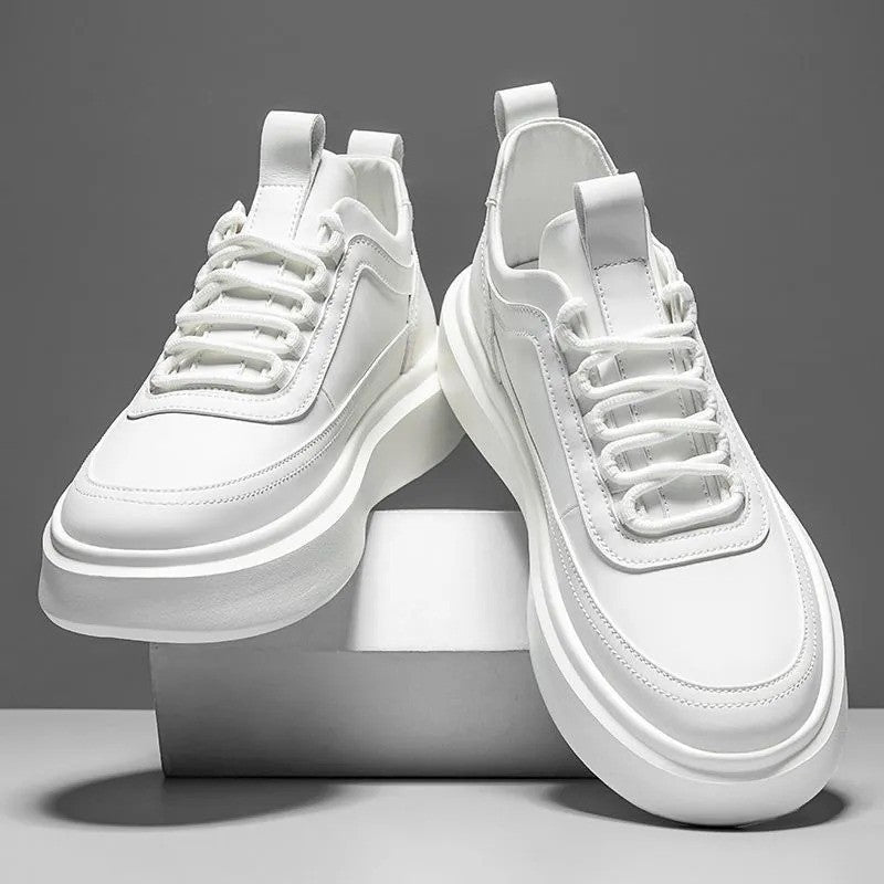 Weiße Sneaker auf grauem Hintergrund, modernes Design, dicke Sohle, Schnürsenkel, minimalistisch, modisch, Unisex-Sportschuhe, trendige Fußbekleidung.