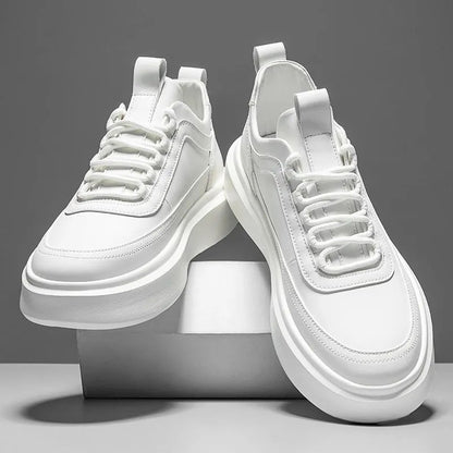 Weiße Sneaker auf grauem Hintergrund, modernes Design, dicke Sohle, Schnürsenkel, minimalistisch, modisch, Unisex-Sportschuhe, trendige Fußbekleidung.