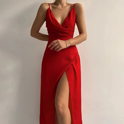 Frau in elegantem roten Abendkleid mit tiefem Ausschnitt und hohem Beinschlitz vor weißem Hintergrund. Perfekt für formelle Anlässe und Modeevents.