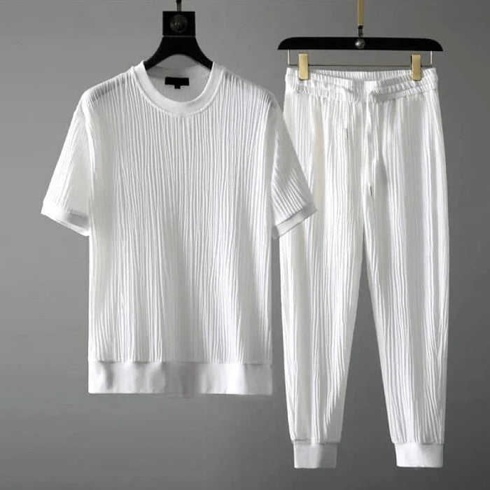 Weißer gerippter T-Shirt und Jogginghose Set auf Kleiderbügeln, minimalistisch, modisch, bequem, ideal für Freizeitkleidung, unisex Design.