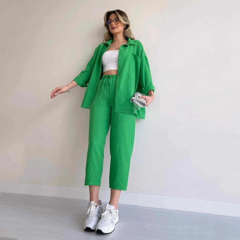 Frau in grünem Zweiteiler mit weißem Top und Sneakers, hält eine kleine Tasche. Modetrend, lässiger Stil, Frühlingsoutfit, Damenmode.