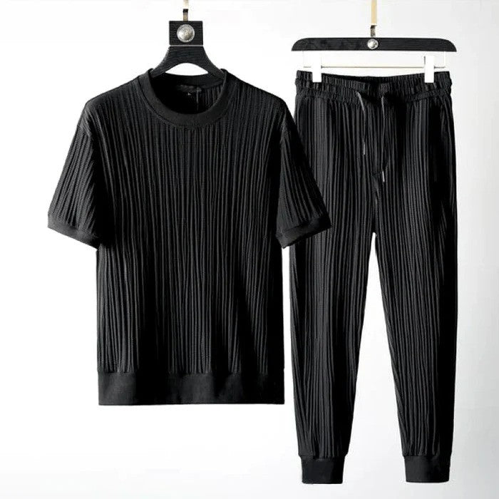 Schwarzes geripptes T-Shirt und Jogginghose-Set auf Kleiderbügeln, moderne Herrenmode, bequeme Freizeitkleidung, stilvolles Design.