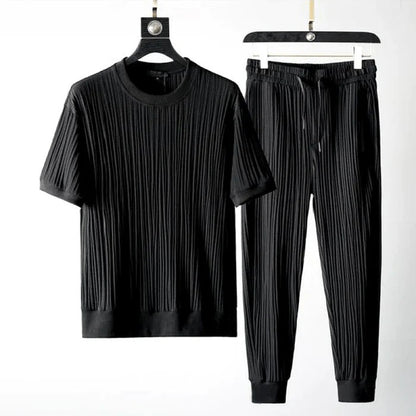 Schwarzes geripptes T-Shirt und Jogginghose-Set auf Kleiderbügeln, moderne Herrenmode, bequeme Freizeitkleidung, stilvolles Design.