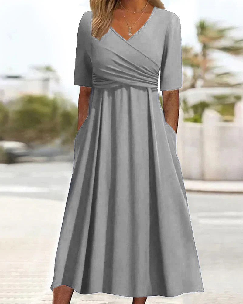 Graues Damenkleid mit V-Ausschnitt und kurzen Ärmeln, knielang, mit Taschen, ideal für Sommermode und Freizeitkleidung.