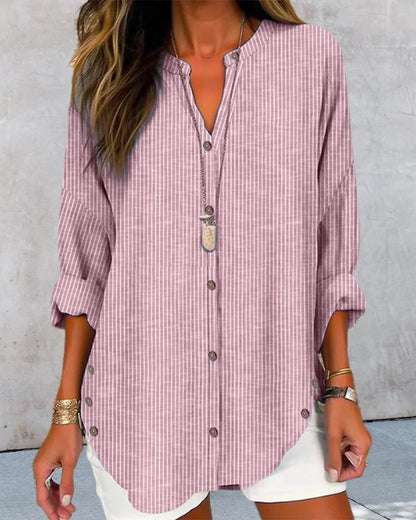 Damenmode: Lässige, gestreifte Bluse in Rosa mit Knopfleiste und langen Ärmeln, kombiniert mit weißer Hose. Perfekt für Sommer und Freizeit.