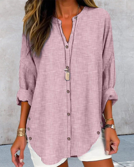 Damenmode: Lässige, gestreifte Bluse in Rosa mit Knopfleiste und langen Ärmeln, kombiniert mit weißer Hose. Perfekt für Sommer und Freizeit.