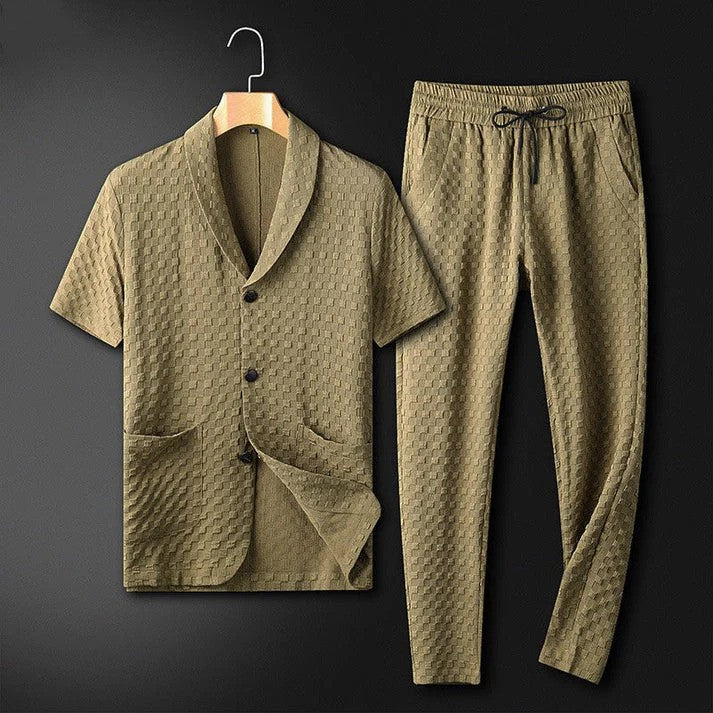Zweiteiliges Herren-Set aus olivgrünem, strukturiertem Stoff mit Kurzarmhemd und Kordelzughose auf schwarzem Hintergrund. Elegante Freizeitmode.