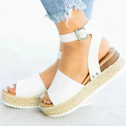 Weiße Sandalen mit Plateau und Knöchelriemen, getragen mit zerrissenen Jeans. Modische Sommerschuhe, ideal für Damenmode und Freizeitoutfits.