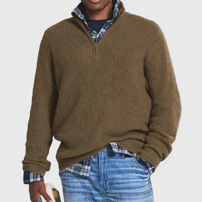 Mann in braunem Strickpullover mit Reißverschluss, kariertem Hemd und blauer Jeans. Modischer Freizeitlook für Herren.