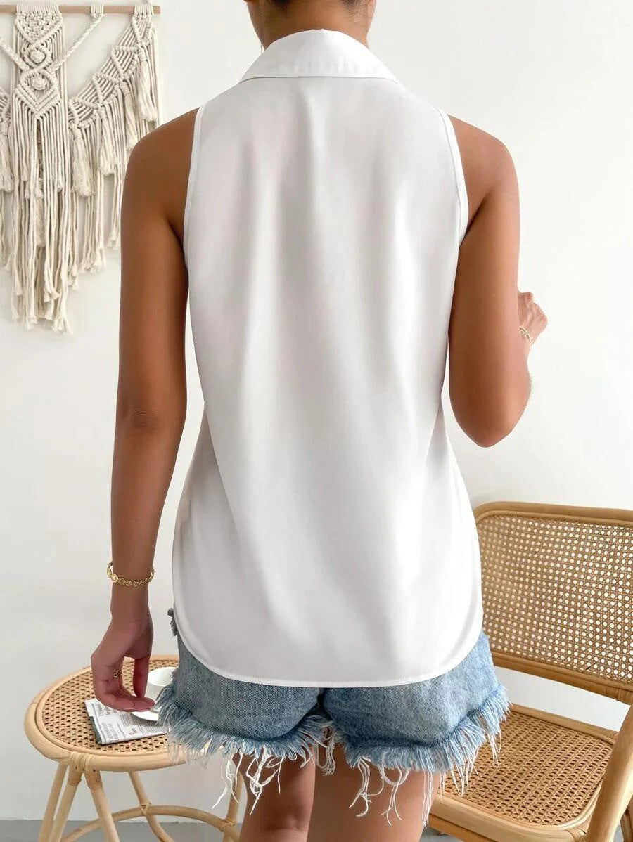 Rückansicht einer Frau in weißer ärmelloser Bluse und zerrissenen Jeansshorts, stehend vor einem geflochtenen Stuhl und Makramee-Wanddekoration.