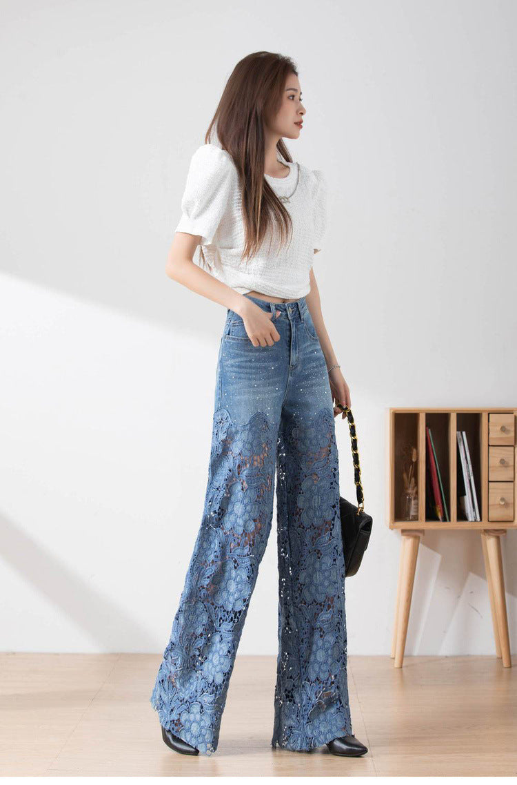 Frau in weißem Oberteil und blauer Spitzenhose, steht in modernem Raum. Modetrend, Damenmode, elegante Kleidung, Freizeitlook.