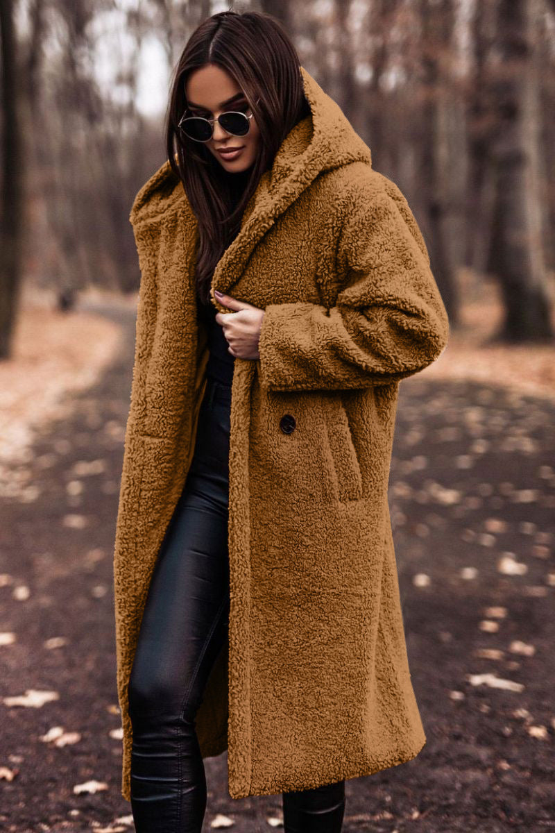 Frau im braunen Teddy-Mantel und Sonnenbrille im Herbstwald. Modetrend, Herbstmode, stilvoller Look, Outdoor-Fashion.