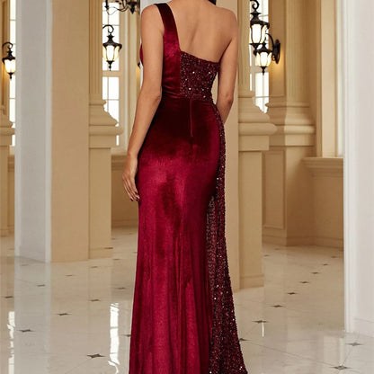 Rückansicht einer Frau in einem eleganten, roten Abendkleid mit Pailletten, stehend in einem luxuriösen, hellen Raum mit Kronleuchtern.