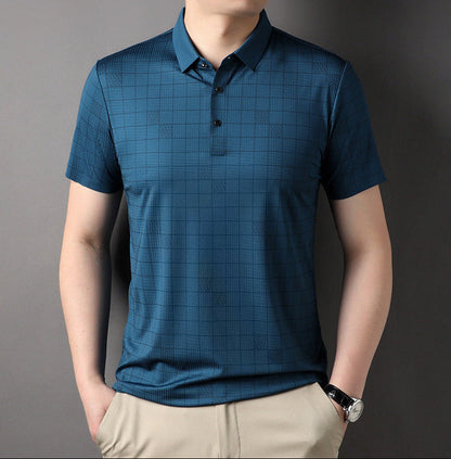 Mann in blauem kariertem Polohemd und beigen Hosen vor grauem Hintergrund, modisches Herrenoutfit, Freizeitkleidung, stilvoller Look.