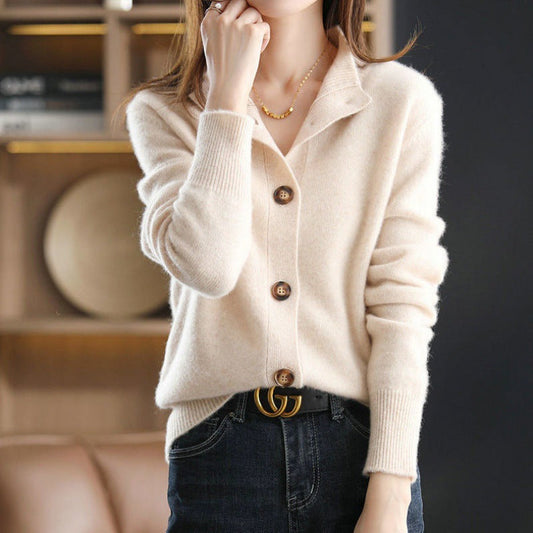 Frau trägt cremefarbenen Strickpullover mit Knöpfen, kombiniert mit schwarzer Jeans und Designer-Gürtel. Elegante Herbstmode, stilvoller Look.