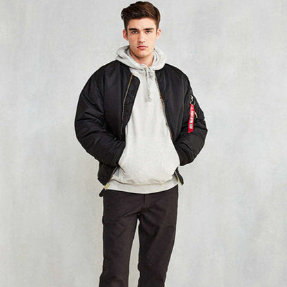 Junger Mann in schwarzer Bomberjacke und grauem Hoodie, lässiger Streetwear-Look, Mode für Herren, urbaner Stil, trendige Freizeitkleidung.