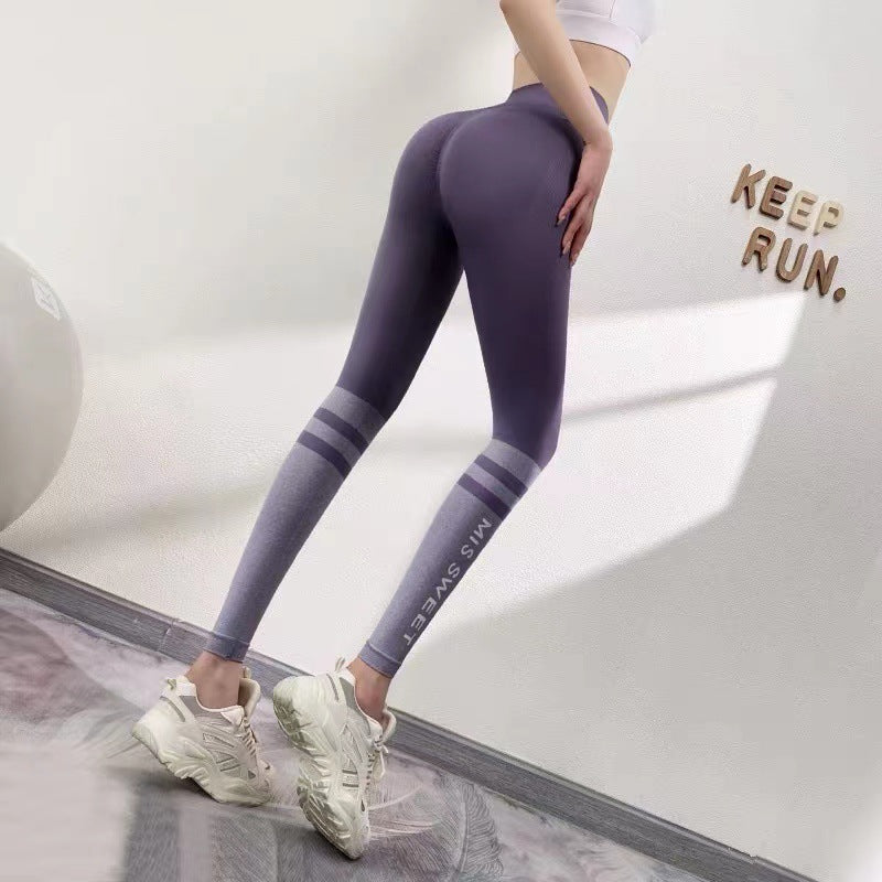Frau in lila Leggings und weißen Sneakers, steht vor einer Wand mit "Keep Run" Schriftzug. Sportbekleidung, Fitness, Mode.